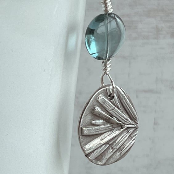 Botanical silver pendant with yew leaf design.