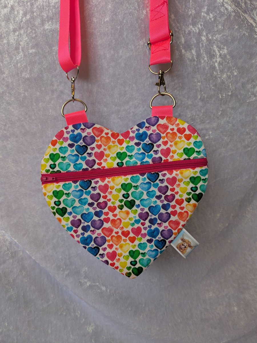 Heart shaped cross body bag with pink strap.