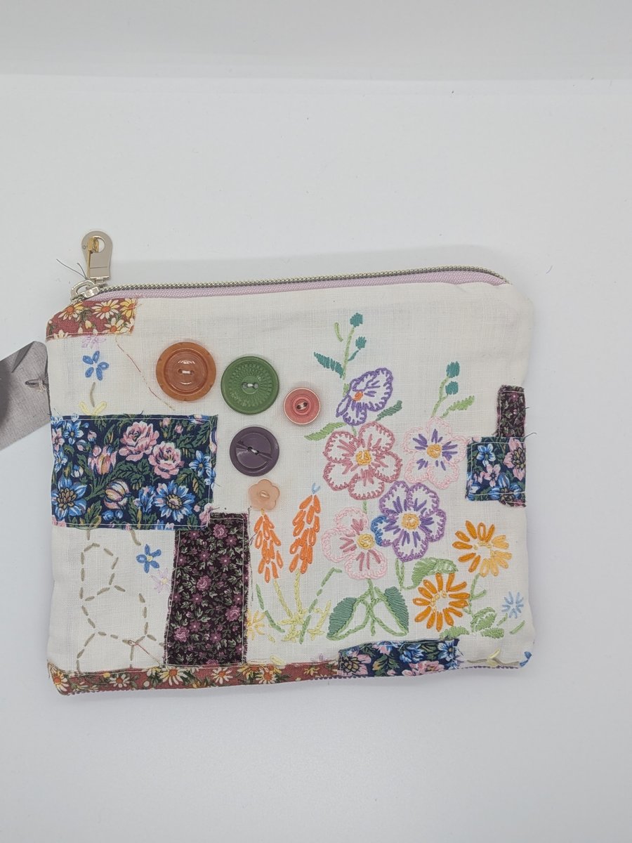 Zipped pouch with embroidery and buttons