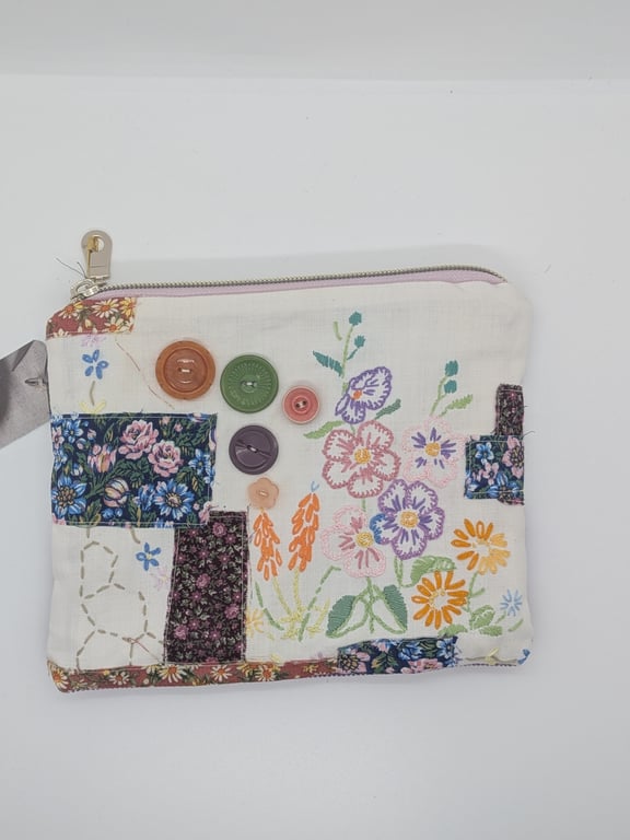 Zipped pouch with embroidery and buttons