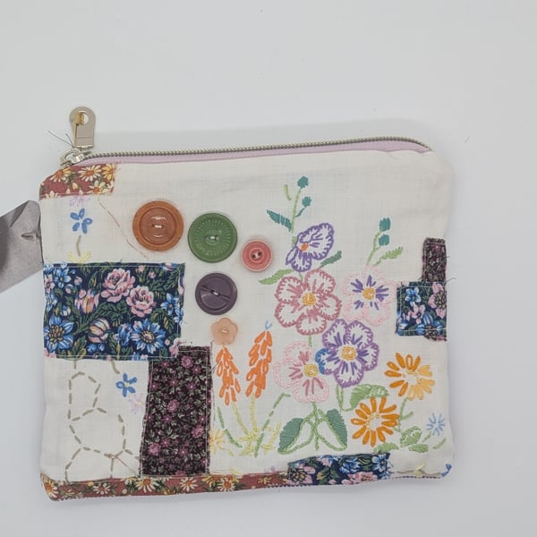 Zipped pouch with embroidery and buttons