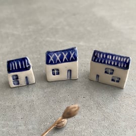Set of three tiny ceramic houses .