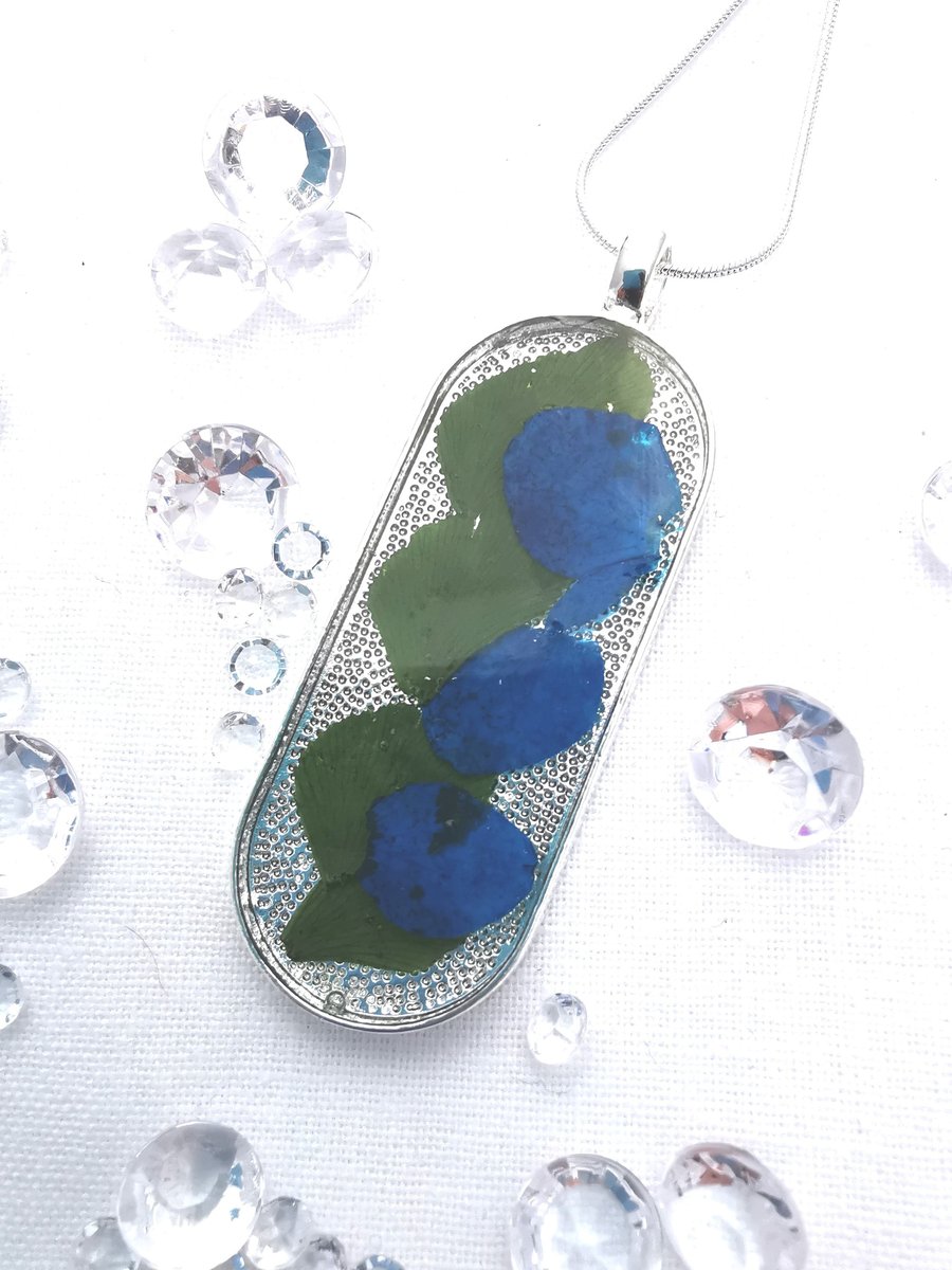 Long Oval Pendant With Blue Flower Petals
