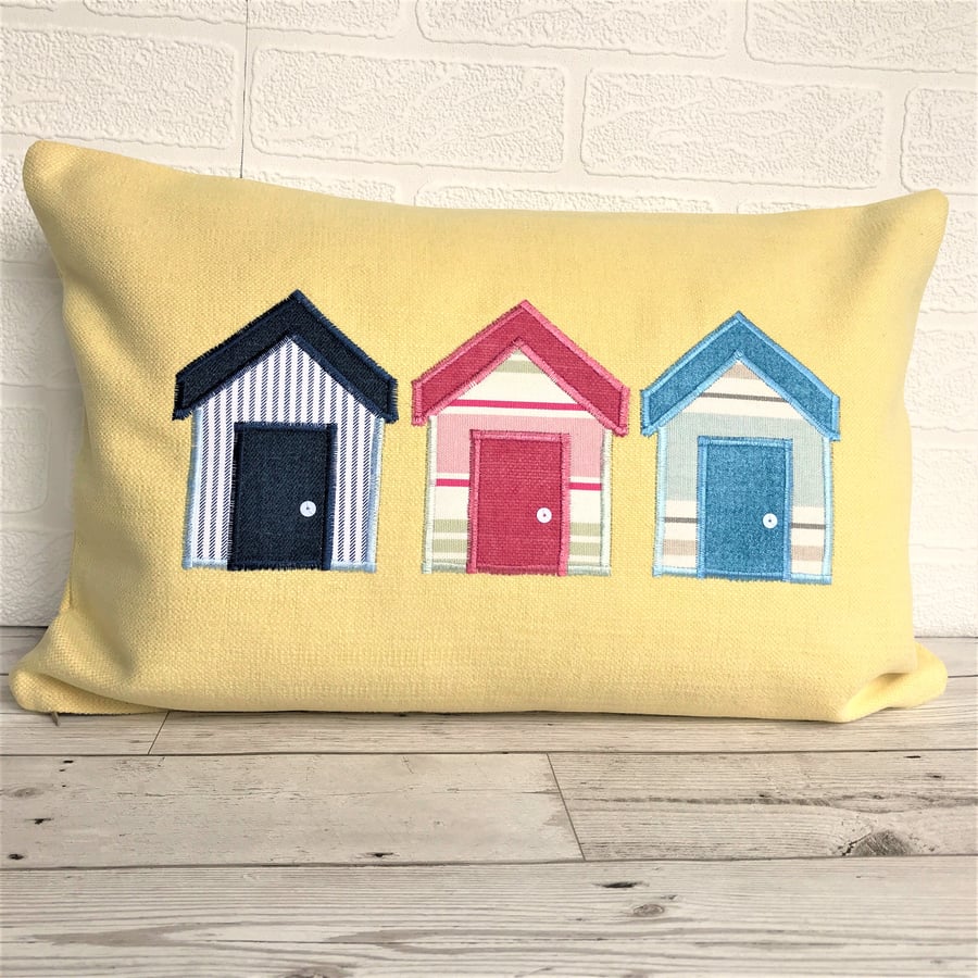 Beach huts cushion in lemon yellow with blue, white and pink beach huts