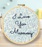 Hand embroidered wall hanging saying I love you mummy on ditsy blue fabric 