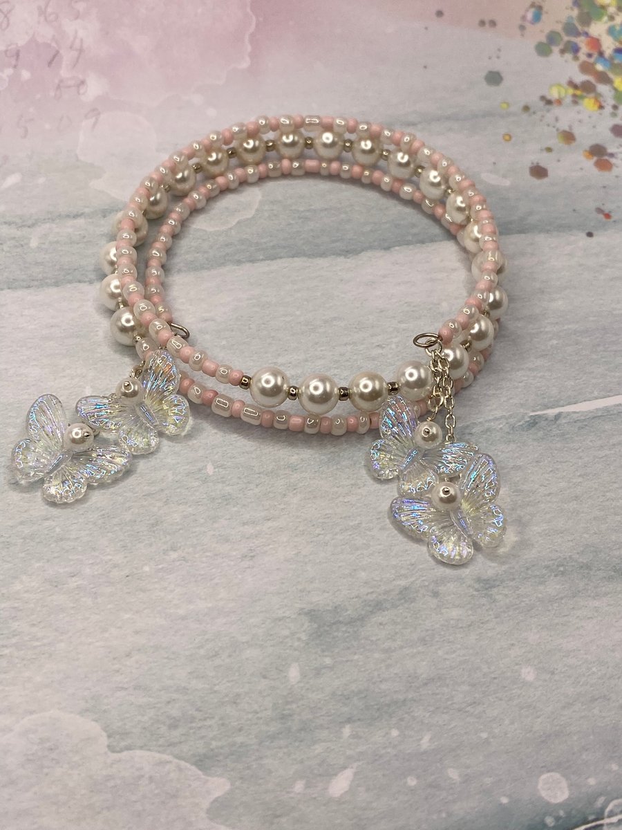 Pale pink and shell pearl beaded memory wire bangle with butterfly charms