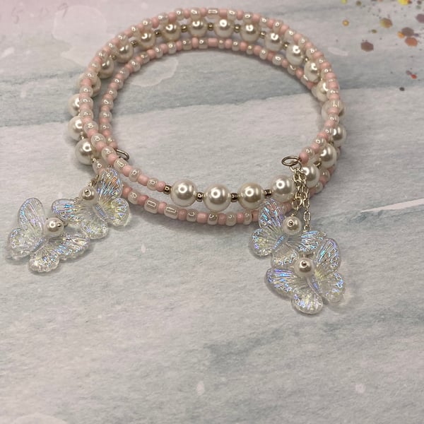 Pale pink and shell pearl beaded memory wire bangle with butterfly charms