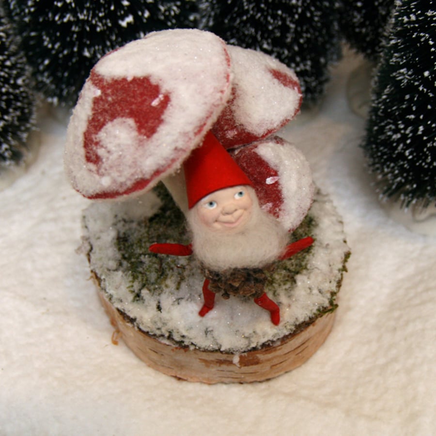Folk art Christmas pixie sitting on snow covered toadstool