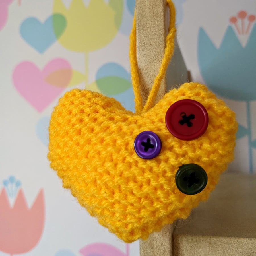 Hand-knitted yellow button heart