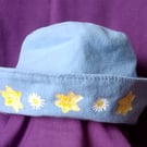 Hat for teens, powder blue with yellow painted flowers.