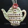 Ceramic teapot decoration with red flower