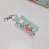 Key ring lip balm holder in blue and pink vintage style print.