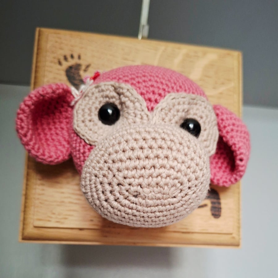 Crocheted monkey trophy head on wooden board