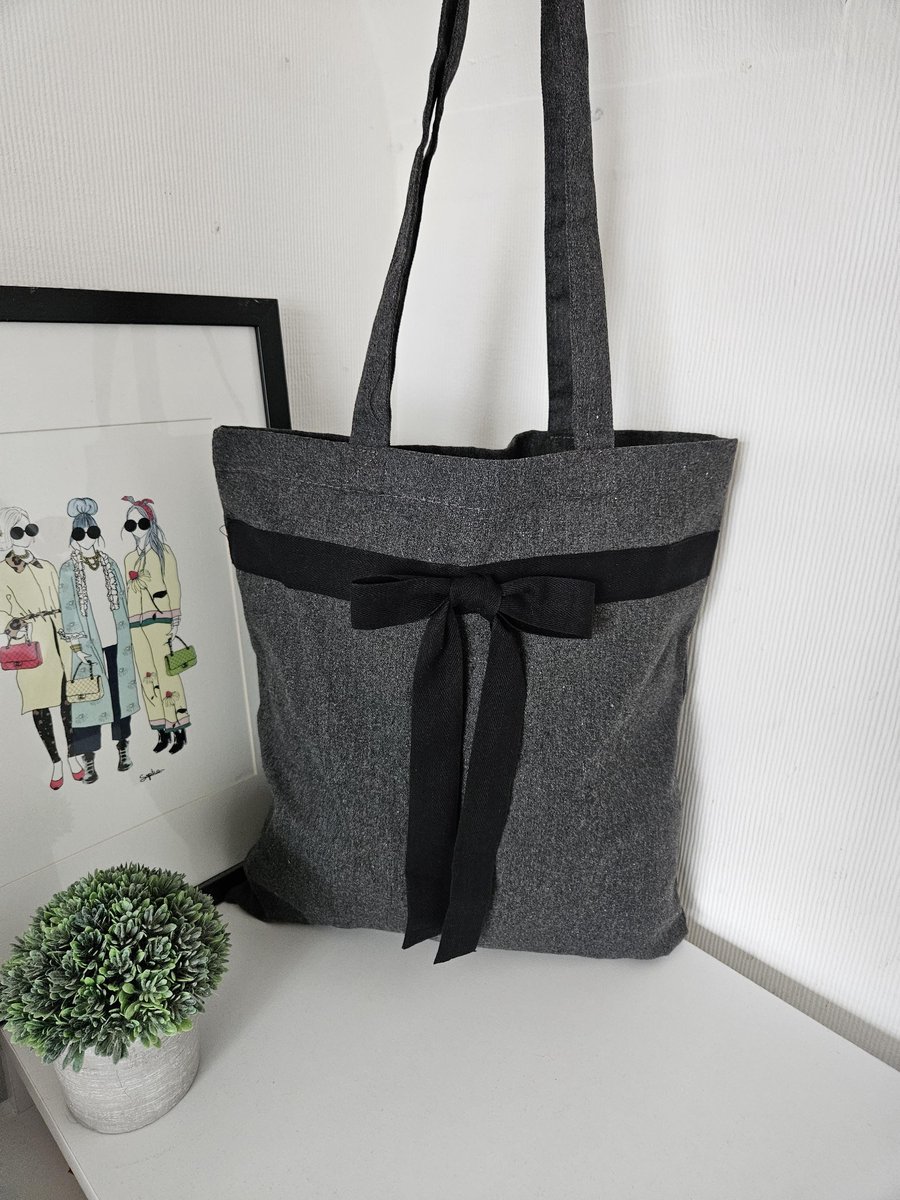 Chic, grey tote made from a blend of recycled materials, styled with a black cot