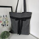Chic, grey tote made from a blend of recycled materials, styled with a black cot
