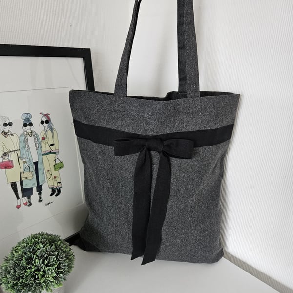 Chic, grey tote made from a blend of recycled materials, styled with a black cot