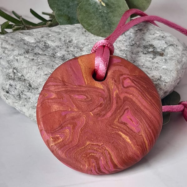 Attractive bronze swirl round polymer clay pendant