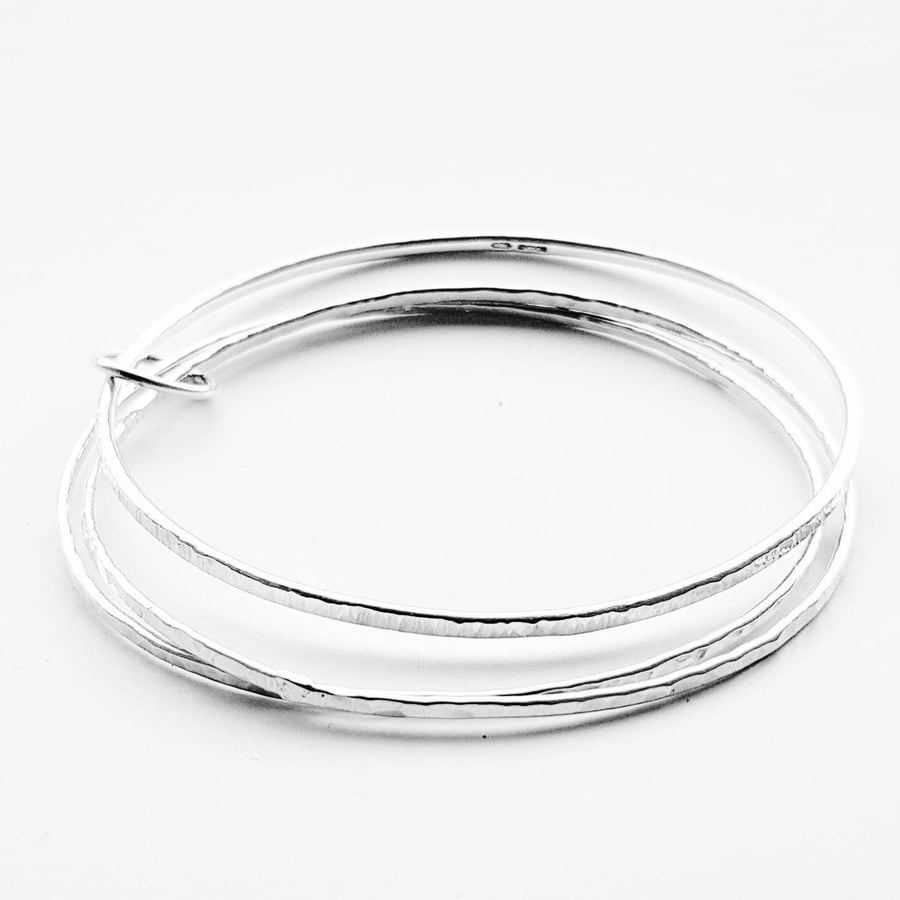 Three slim sterling silver bangles linked with a circle