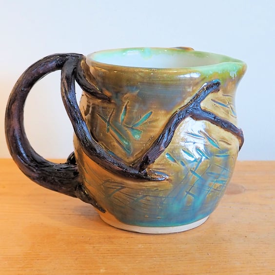 Pottery tree jug finished in green and brown bark colour glazes