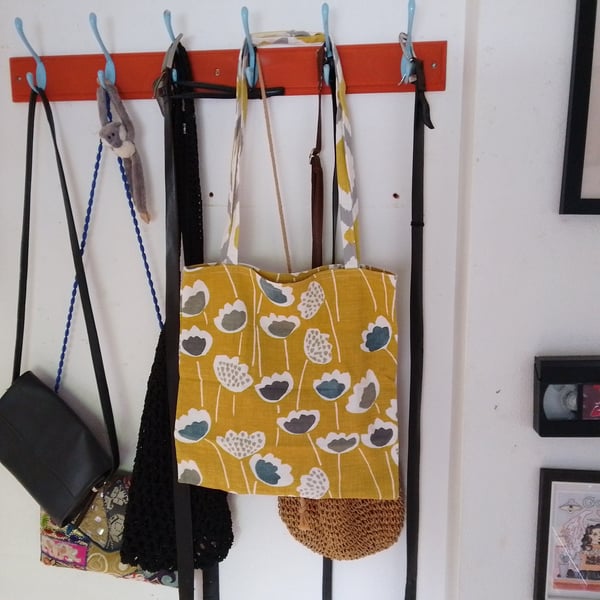 Tote bag made from mustard yellow fabric with flower design.