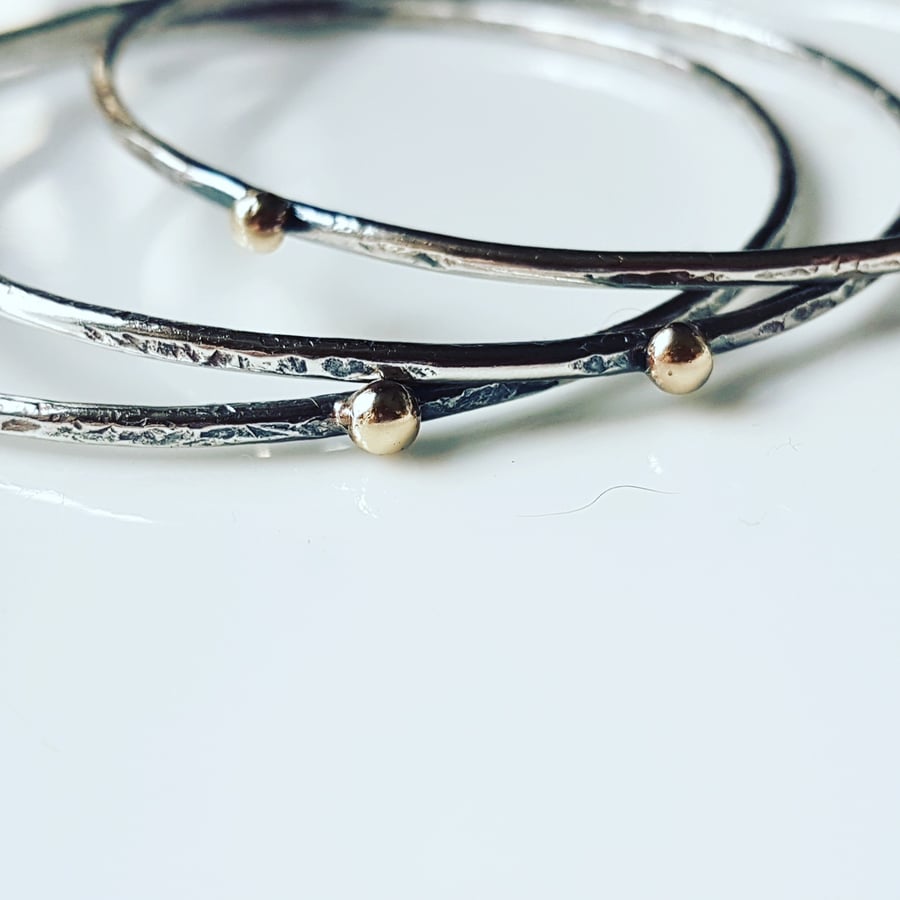 Stacking bangles with an organic texture and a 9ct gold ball