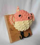 Crocheted puffer fish head on wooden board with hooks