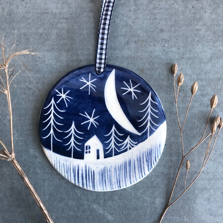 Ceramic Winter scene hanging decoration.