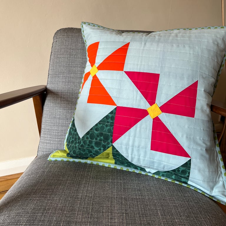 Geometric pink & orange flowers on a quilted cushion