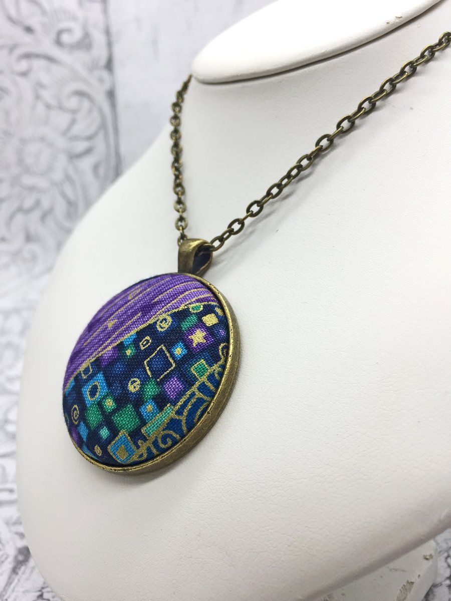 Geometric squares and dashes fabric button pendant in purples, blues and jades