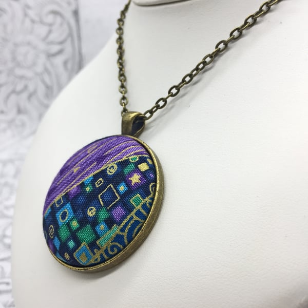 Geometric squares and dashes fabric button pendant in purples, blues and jades