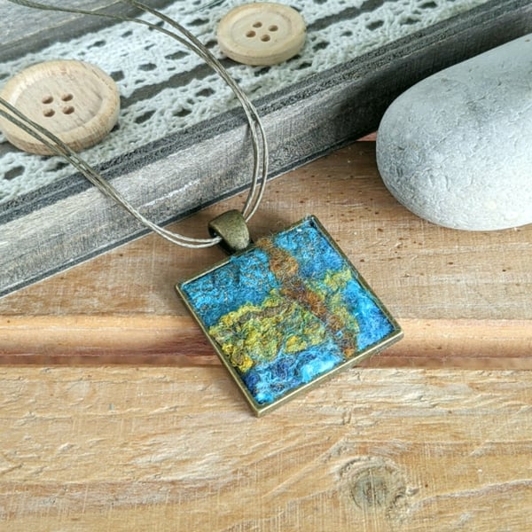 Felted square pendant - blue grey, hint of coral in a bronze bezel