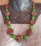 Necklace featuring colourful polymer clay disc shaped beads
