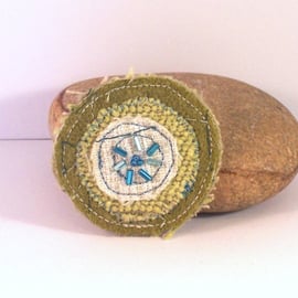 Fabric brooch, circular shape, with machine embroidery in greens