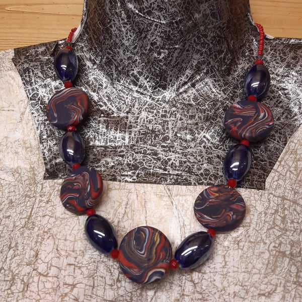 Disc shaped necklace in navy, red and gold 