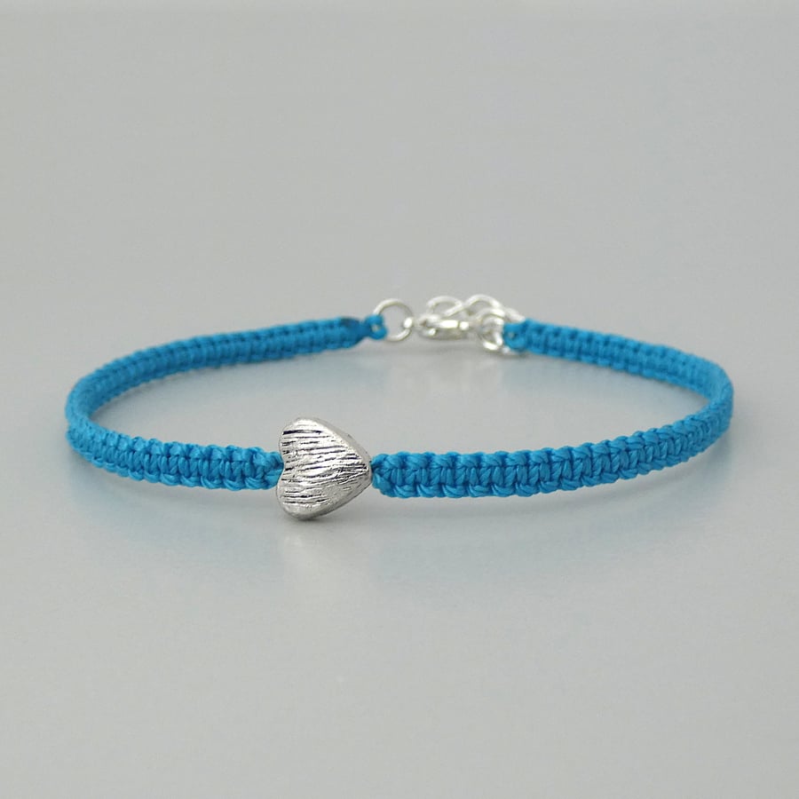 Blue 7" macramé bracelet with silver plated heart charm and 1” extender chain.