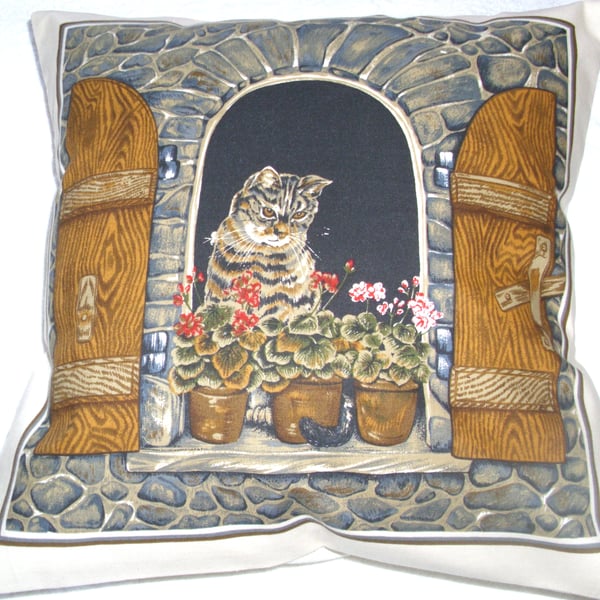 Lovely Grey Tabby cat sitting in window cushion