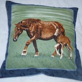 A beautiful brown horse and foal trotting across a field cushion