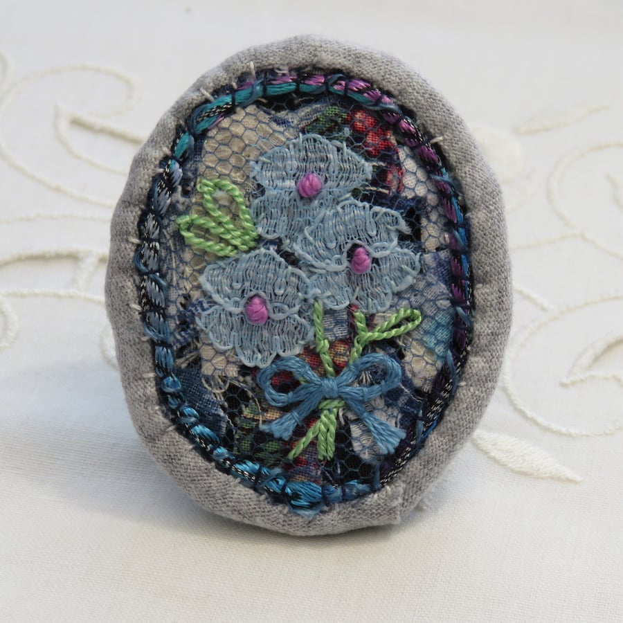 Brooch featuring lace flowers on upcylced background