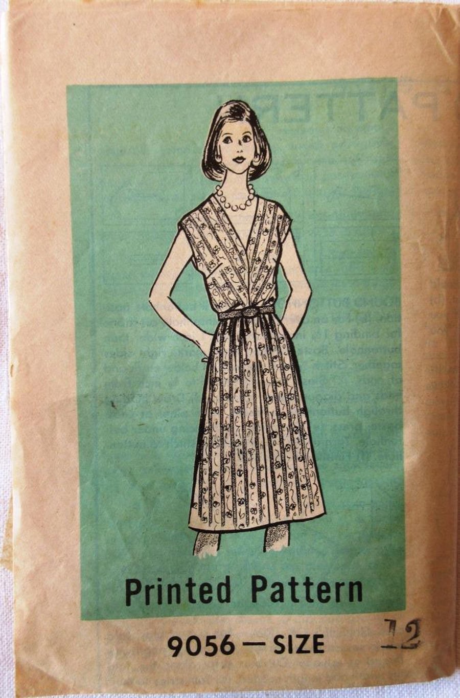 An unused vintage sewing pattern for a woman's cap-sleeved dress in size 12