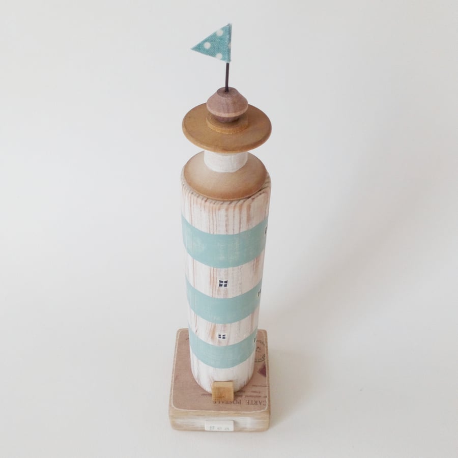 Wooden lighthouse with vintage bobbin and flag 'Sea'