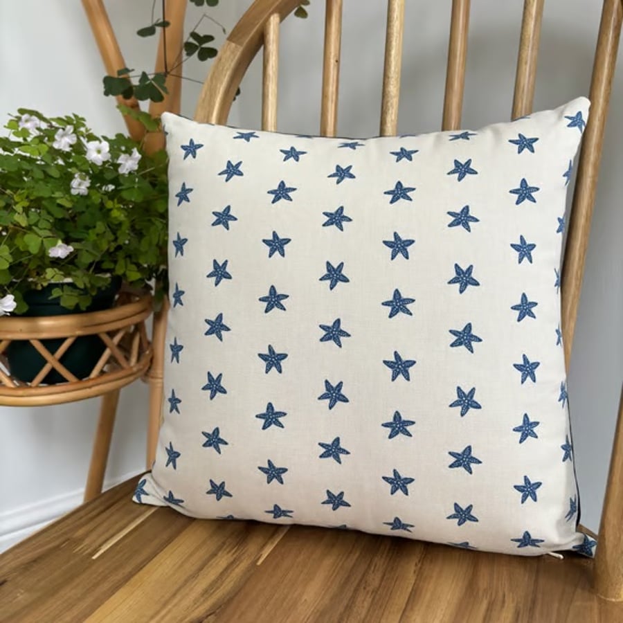 Cushion cover in taupe with navy starfish print, 36cm x 36cm. 
