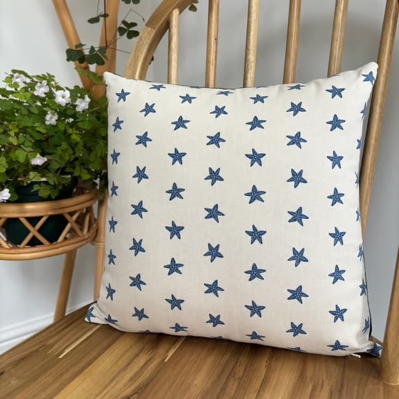 Cushion cover in taupe with navy starfish print, 36cm x 36cm. 