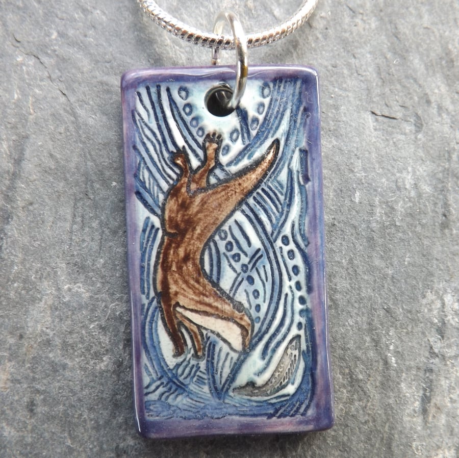 Handmade Ceramic Otter pendant in turquoise blue and purple