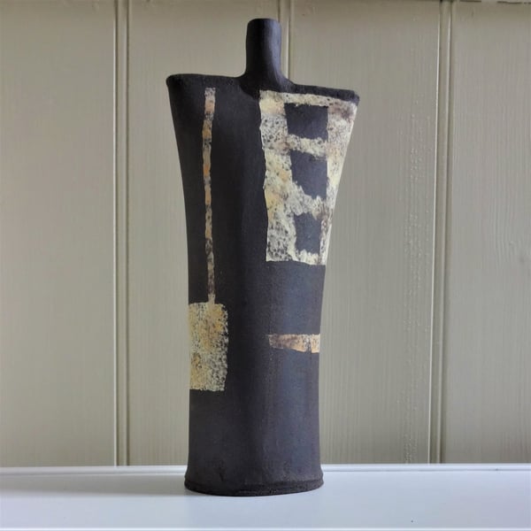 Black ceramic abstract art sculpture, lemon and yellow ochre panels and stripes.