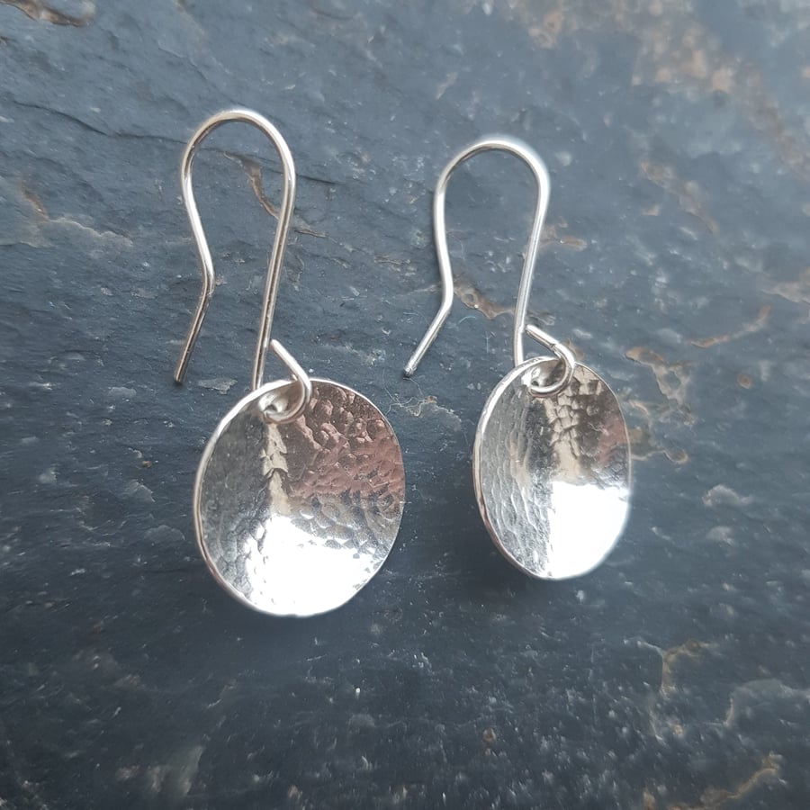 Silver earrings with a hammered domed disc shape