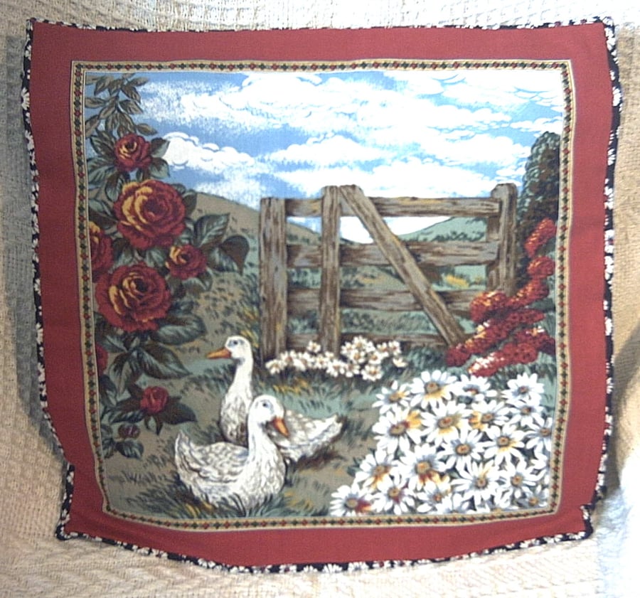 On the farm cushion with two white geese, lots of daisies and roses in a field