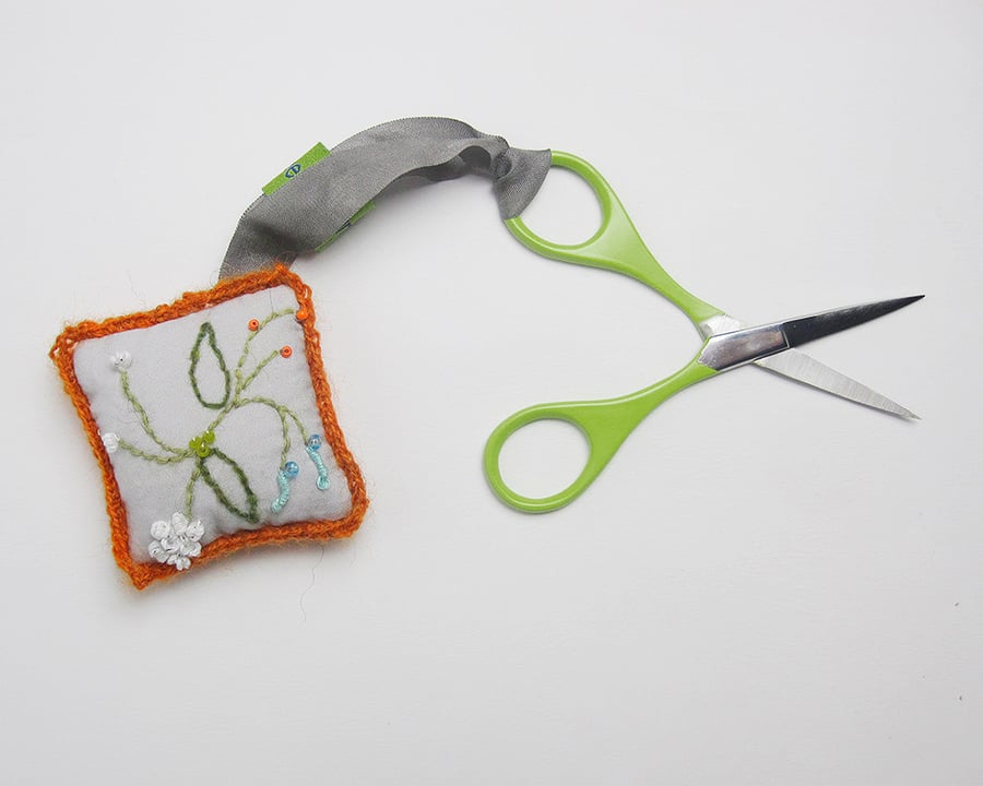 Grey scissor keeper with hand embroidered spring flowers and orange crochet trim