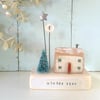 Little wooden house with Christmas tree, button and star