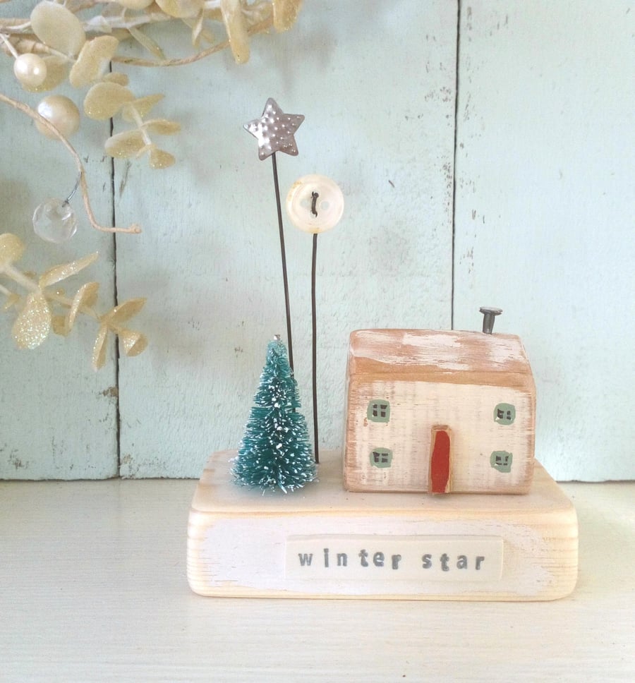 Little wooden house with Christmas tree, button and star