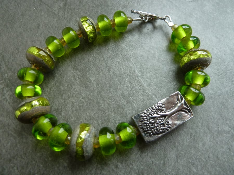 sterling silver, green sparkly lampwork glass and pewter tree bracelet